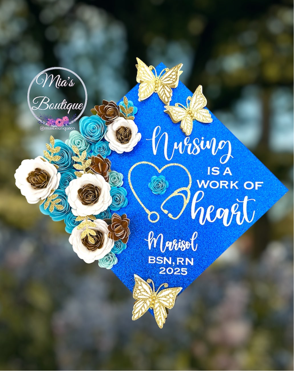 Custom Personalized Nurse Graduation Cap Topper Blue Heart Stethoscope with Nursing Is A Work Of Heart Message and Floral Sunflowers Blue White Gold Flowers Gold Butterfly